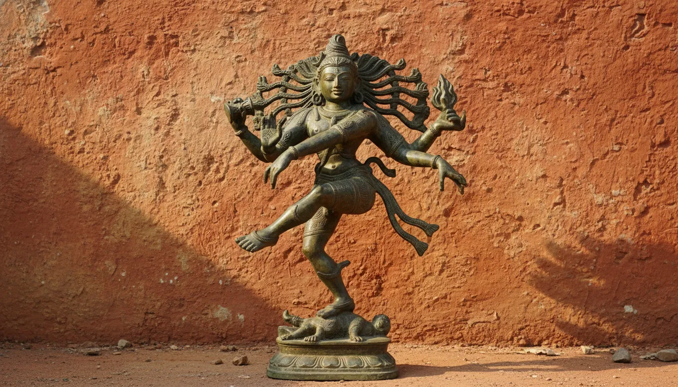 Antique finish bronze Shiva statue in a dancing pose against an earthy terracotta wall