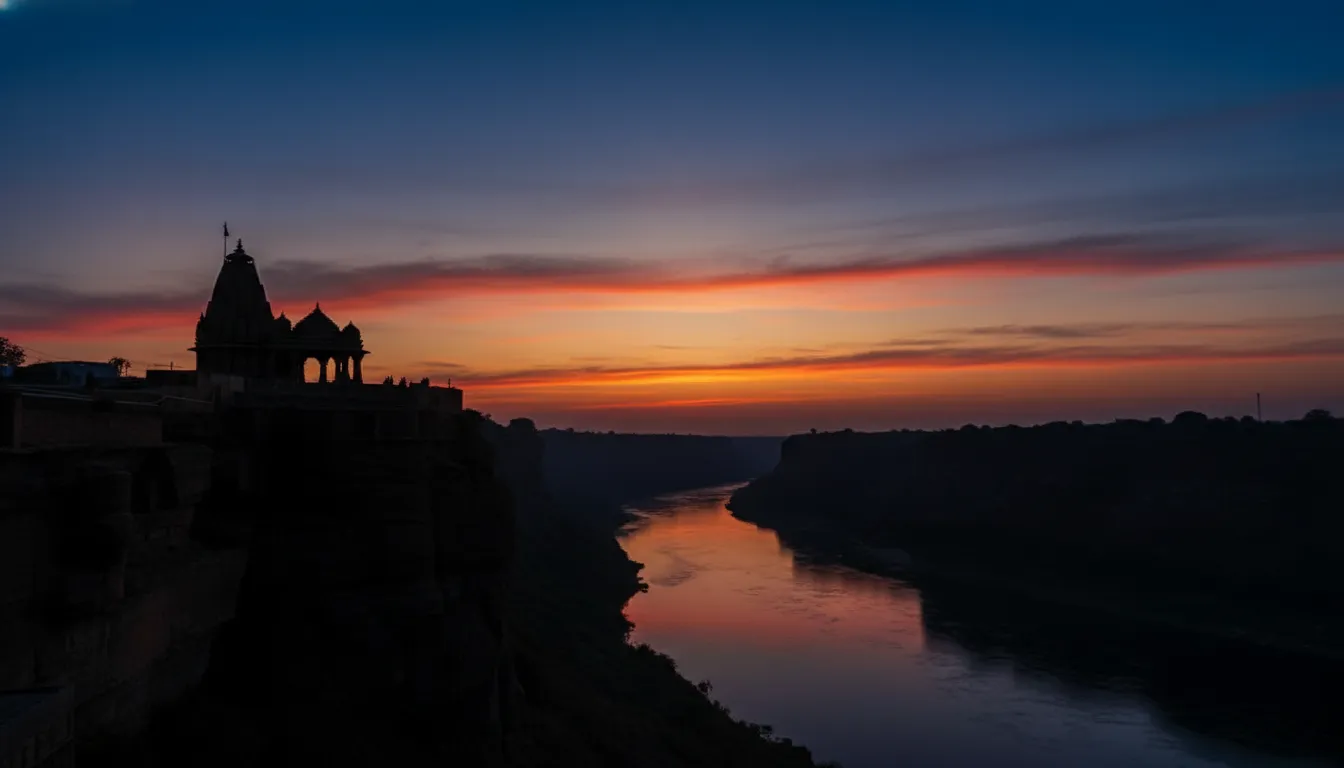 Silhouette of Garadia Mahadev temple against a deep blue and orange twilight sky after sunset.