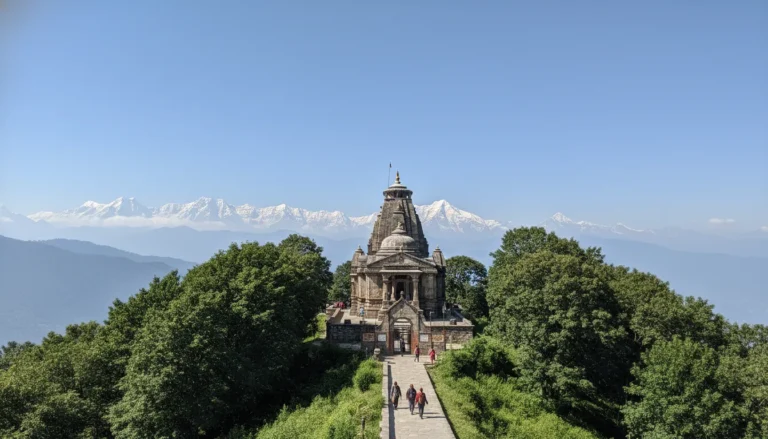 Mukteshwar Mahadev Temple situated on a green hill with a clear blue sky.