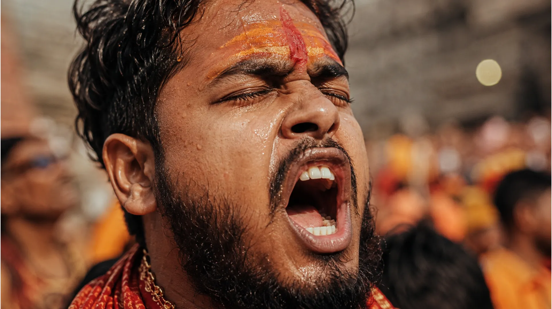 A high-quality clear photo camera portrait focusing sharply on a young man's face, eyes closed, shouting the mantra Har Har Mahadev with intense devotion.
