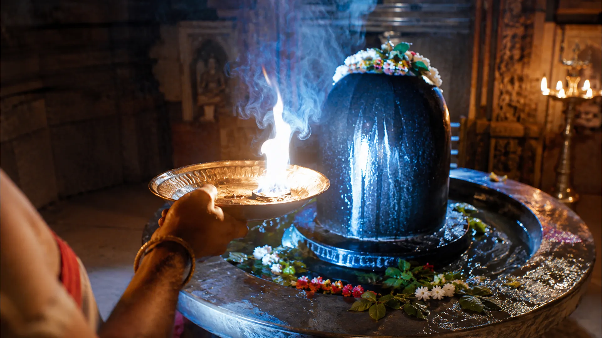 High definition Tarakeswar shivling image featuring a bright camphor flame offering during morning aarti.
