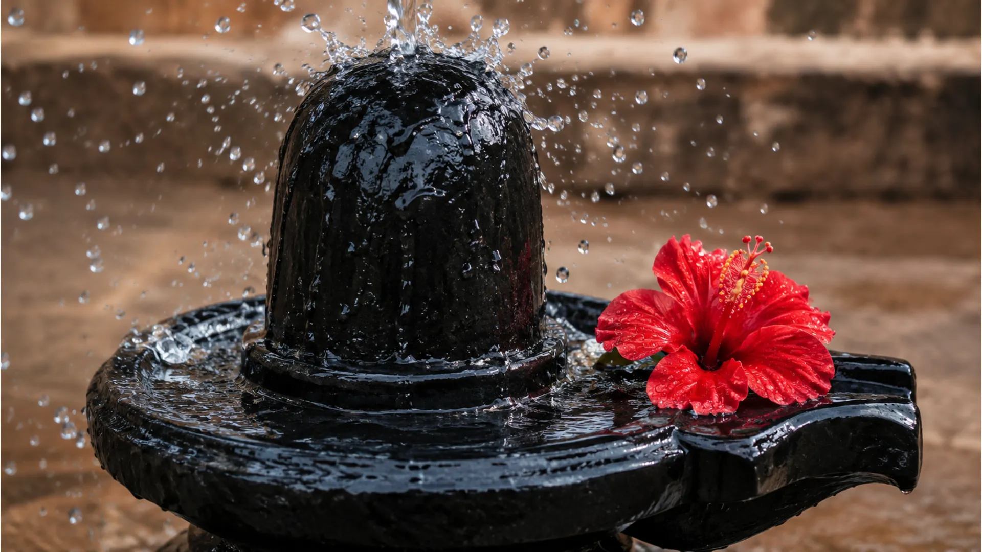 Water droplets splashing on black stone shivling during prayer