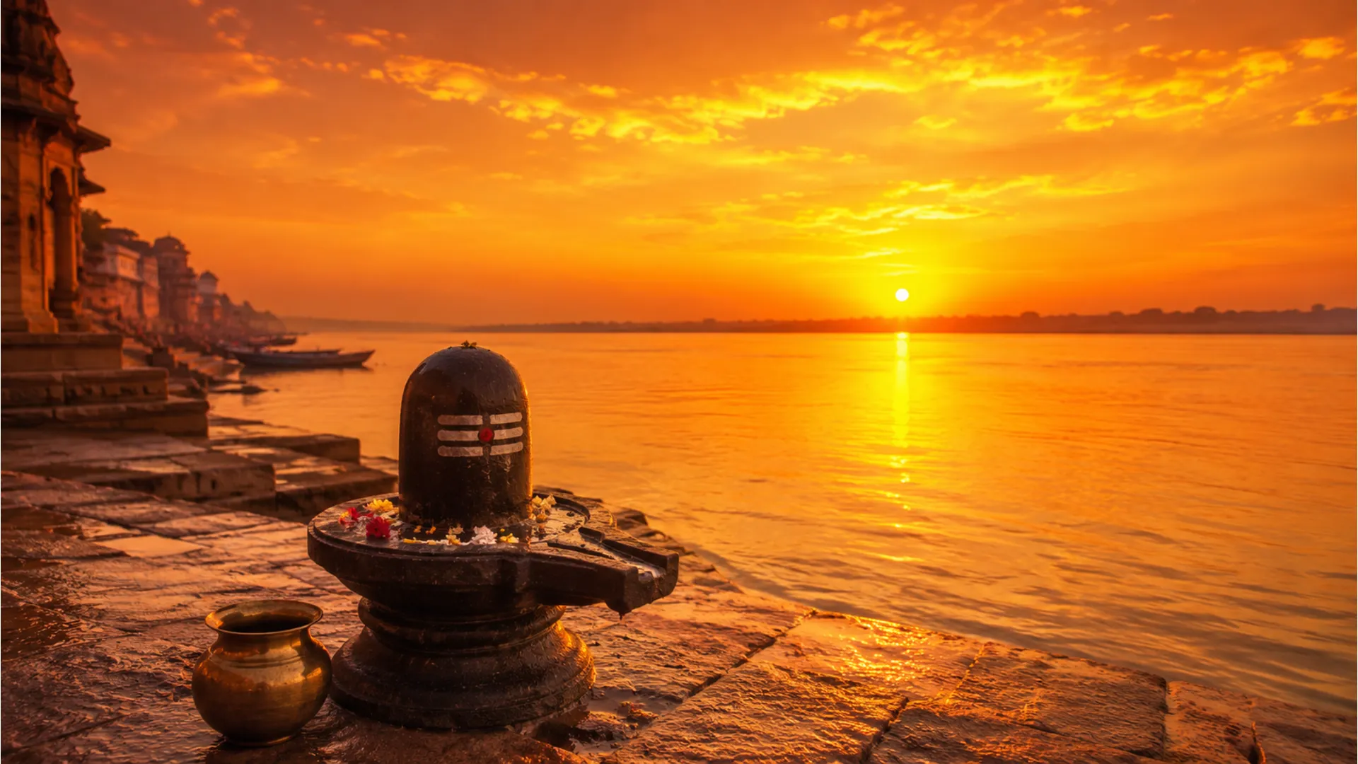 Stone Shivling on a river bank during a vibrant golden sunrise